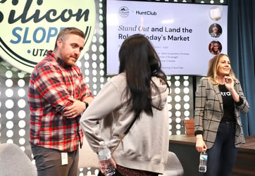 man listening intently to a woman in the foreground at a silicon valley slopes panel event on recruiting