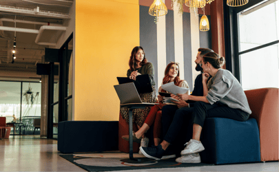 group of professionals sitting around a laptop