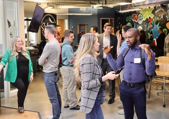 action shot of a large group of recruiting professionals in conversation with one another at a recruiting event