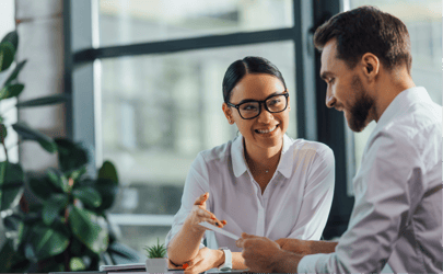 woman in glasses smiling and interviewing man for executive director role