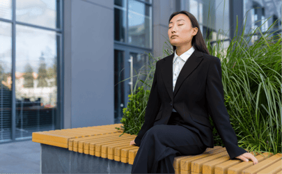 business woman sitting on a bench with closed eyes