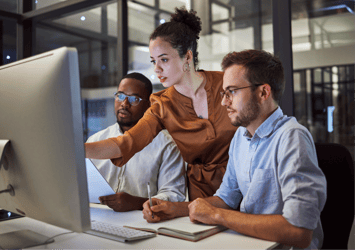 Group of professionals working at a computer.