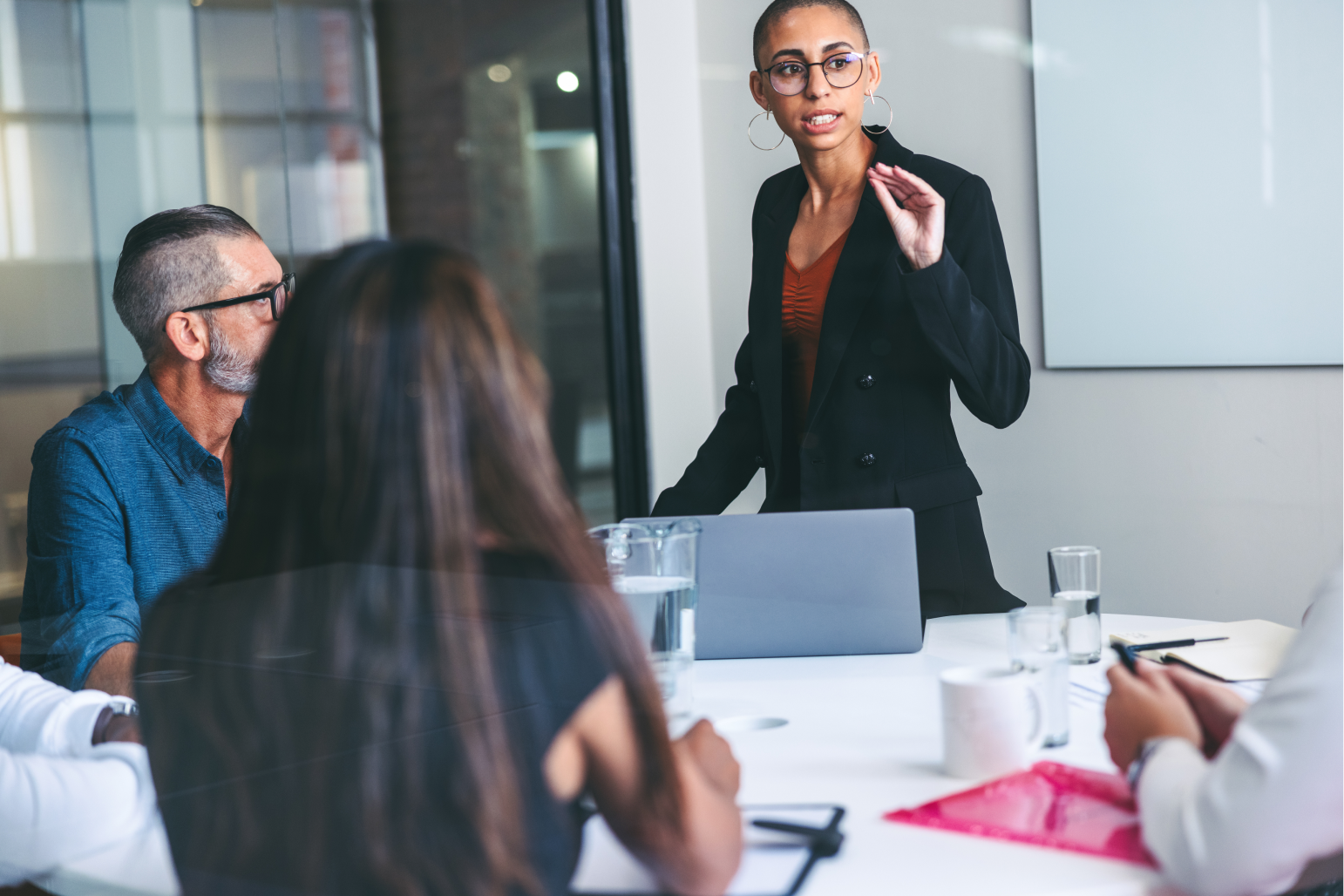 woman leading a meeting with group of people listening in foreground