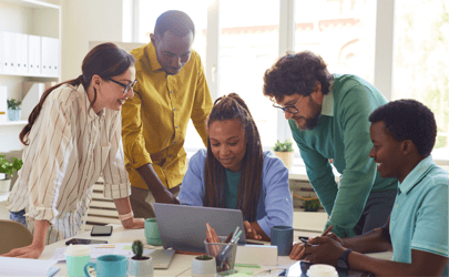 people surrounding a computer in an office