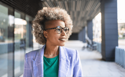 woman with glasses smiling and looking off into distance