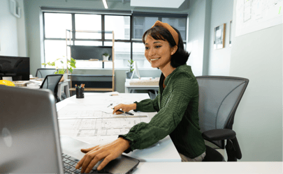 Business woman smiling and working at desk with laptop