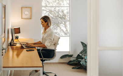 Woman happily working from desk.