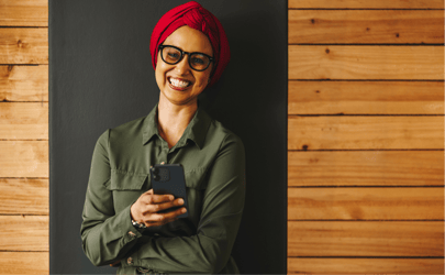 Woman smiling while holding her phone.