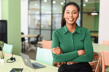 woman in green shirt smiling with arms crossed