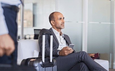 Man sitting in airport holding phone.