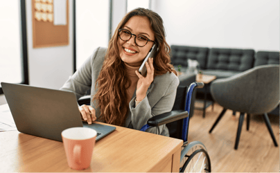 female recruiter sitting with laptop and smiling while on the phone