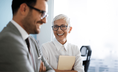 female executive smiling at another man smiling in the foreground