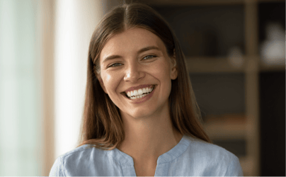 woman in blue shirt smiling directly at camera