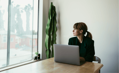 woman in office building looking outside of a window