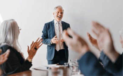 health tech executive in suit giving speech with group of listeners clapping in foreground