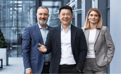 2 male business executives and 1 female business executive in suits smiling at camera