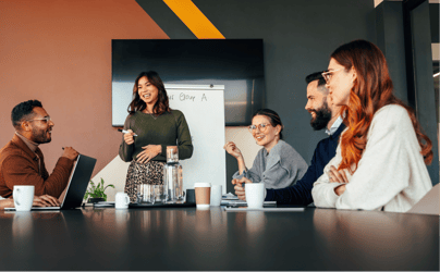 a group of professional colleagues gathered around a desk listening to a presentation