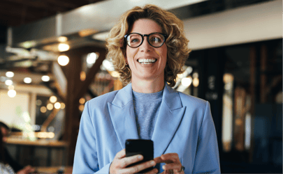 woman in blue business suit holding phone and smiling