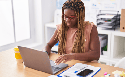 woman sitting at desk and typing on computer