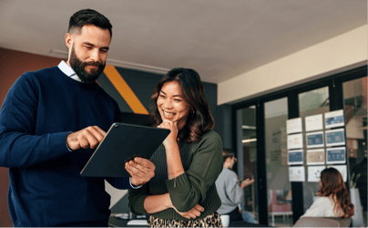 woman and man looking at tablet in office