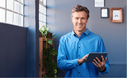 man smiling and holding a tablet