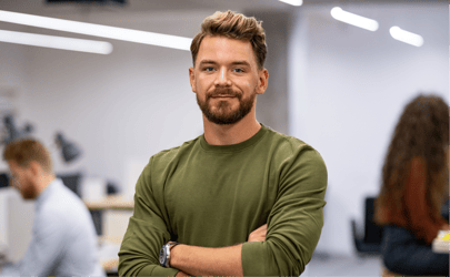 Man in green shirt smiling with crossed arms