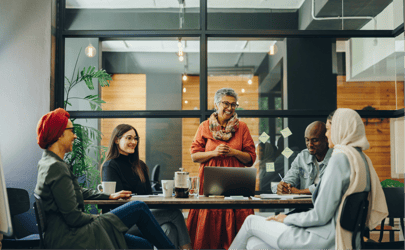 group of diverse office workers gathered around table and smiling