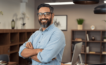 Man in office smiling with arms crossed