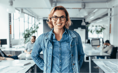 Female executive in denim top smiling at the camera.