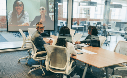 Professionals in a conference room on a zoom call.