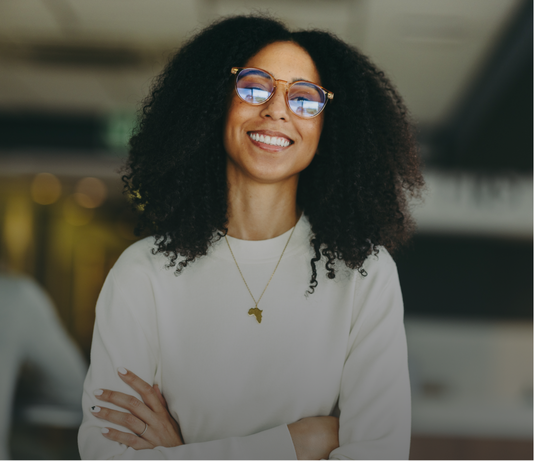 woman with glasses smiling with arms crossed