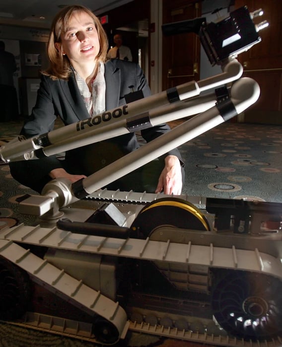 co-founder of iRobot, Helen Greiner, posing with an early iRobot robot