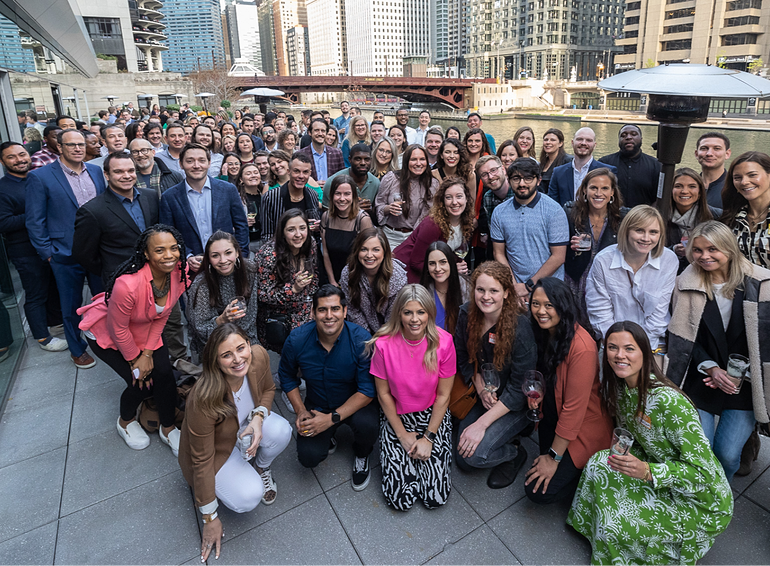 A group shot of Hunt Club employees outside by the Chicago River. 