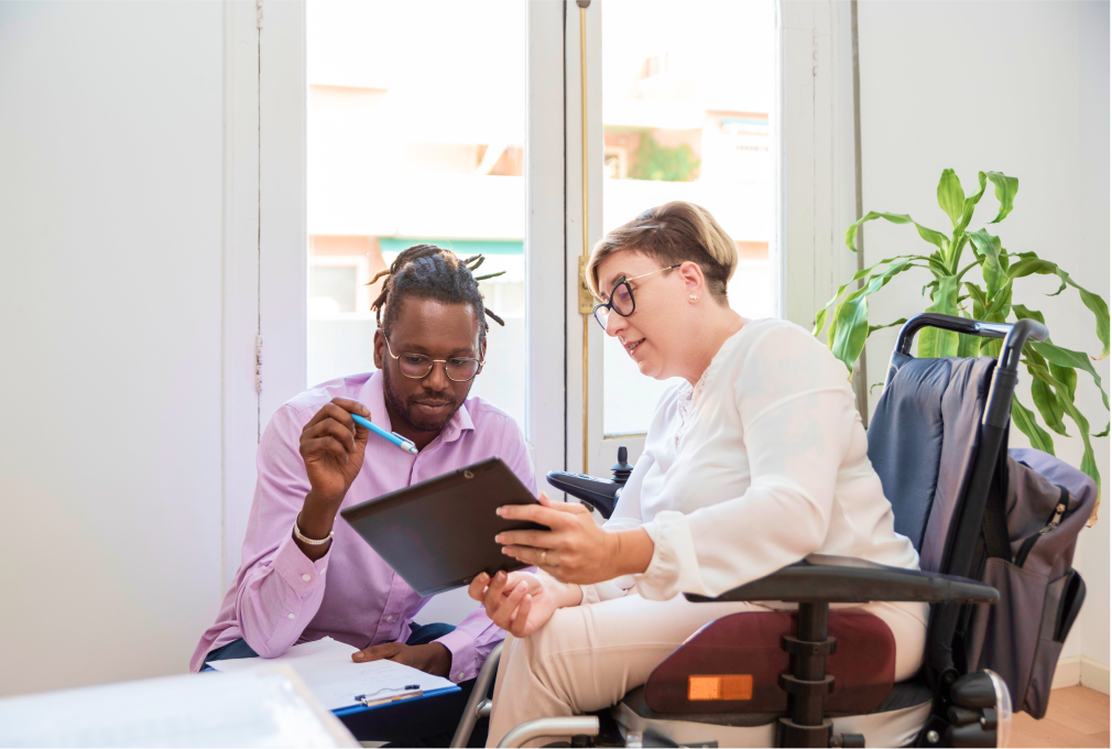 business woman in a wheelchair helping a businessman with work