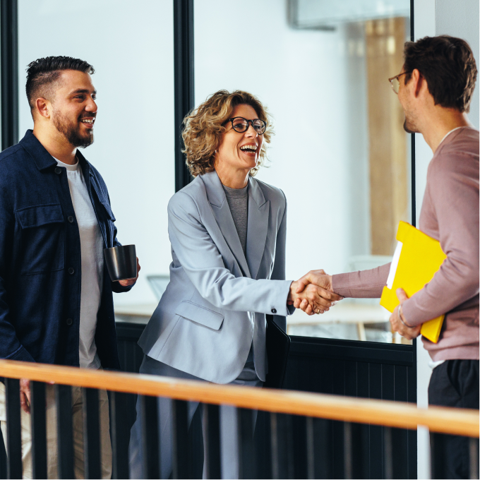 group of three business professionals meeting each other and shaking hands