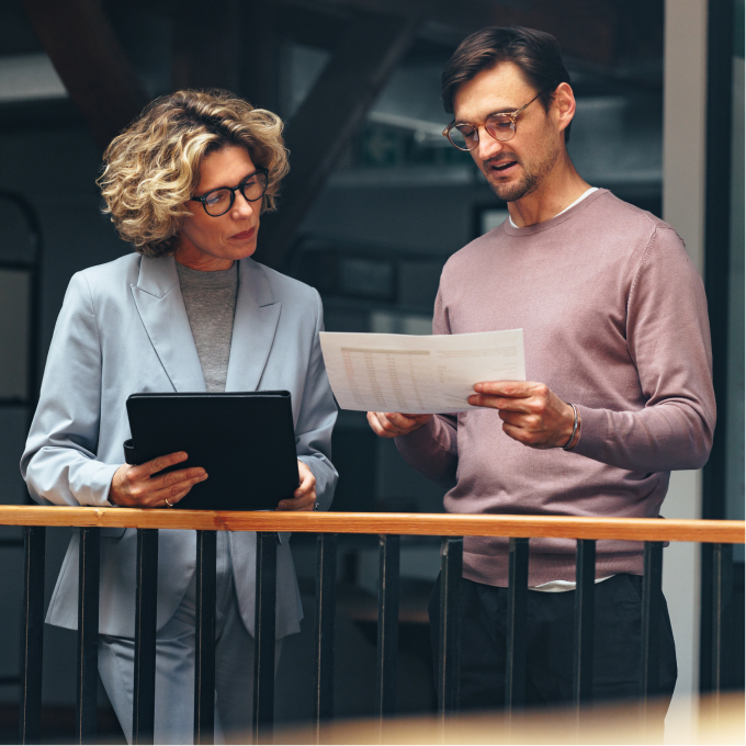 man holding paper document and woman holding folder working together