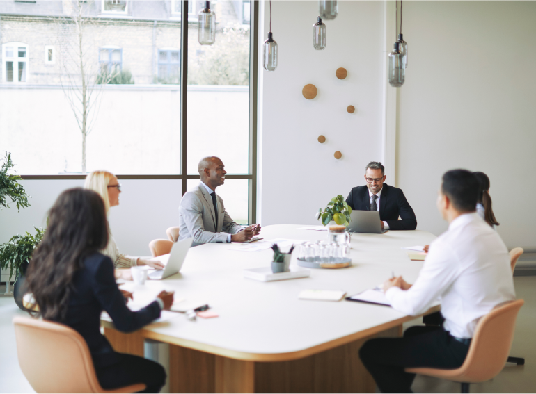 group of professionals meeting and sitting at a large table