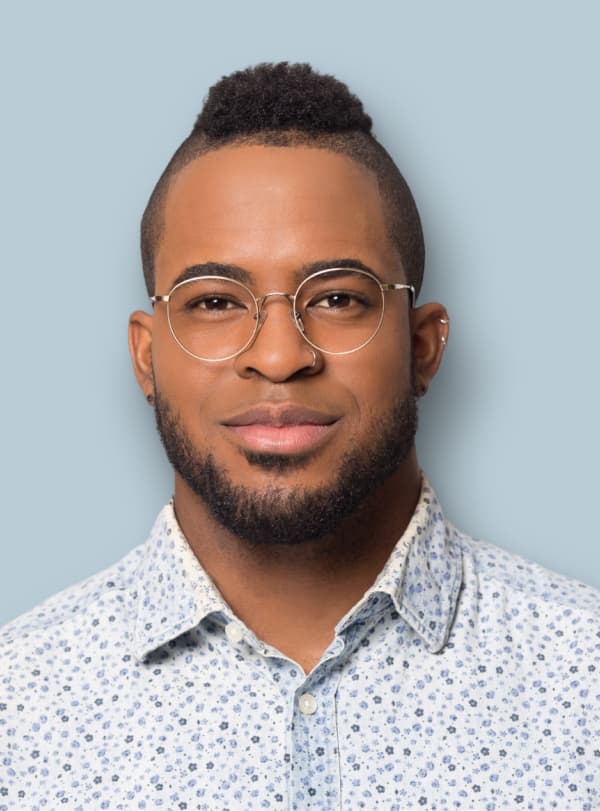 portrait of man with glasses and a collared shirt smiling
