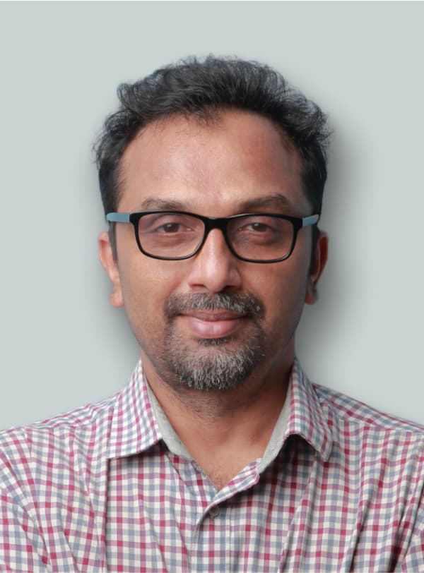 portrait of man in flannel and glasses grinning