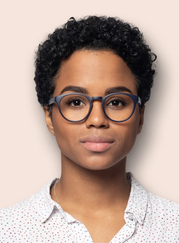 business woman in glasses and a collared shirt smiling at the camera 