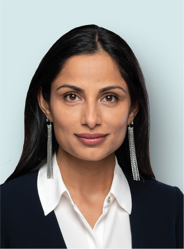 portrait of woman with long earrings and a business suit smiling