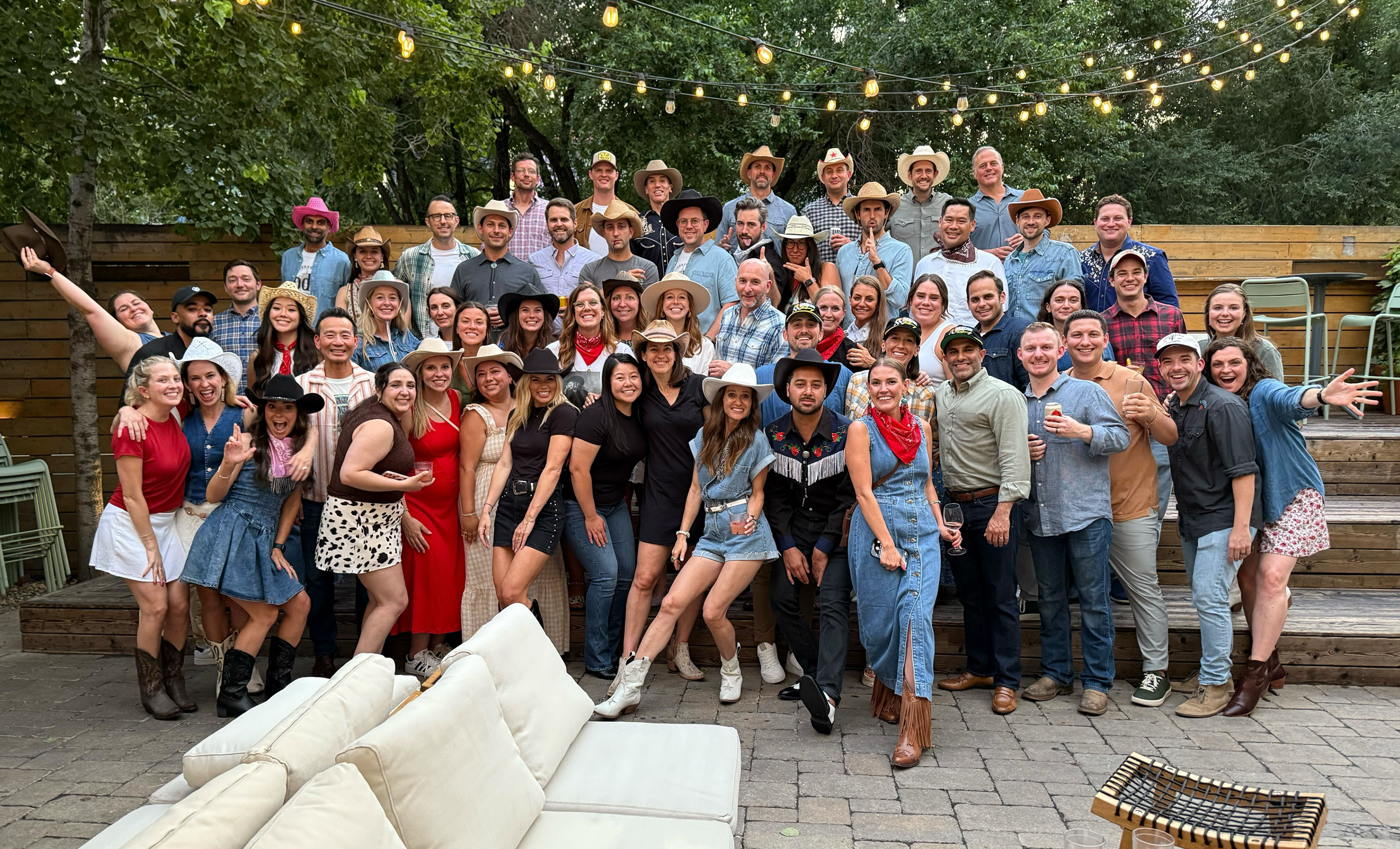 A large group photo of approx. 60 Hunt Club employees at a company on-site event, dressed in western-theme clothing.
