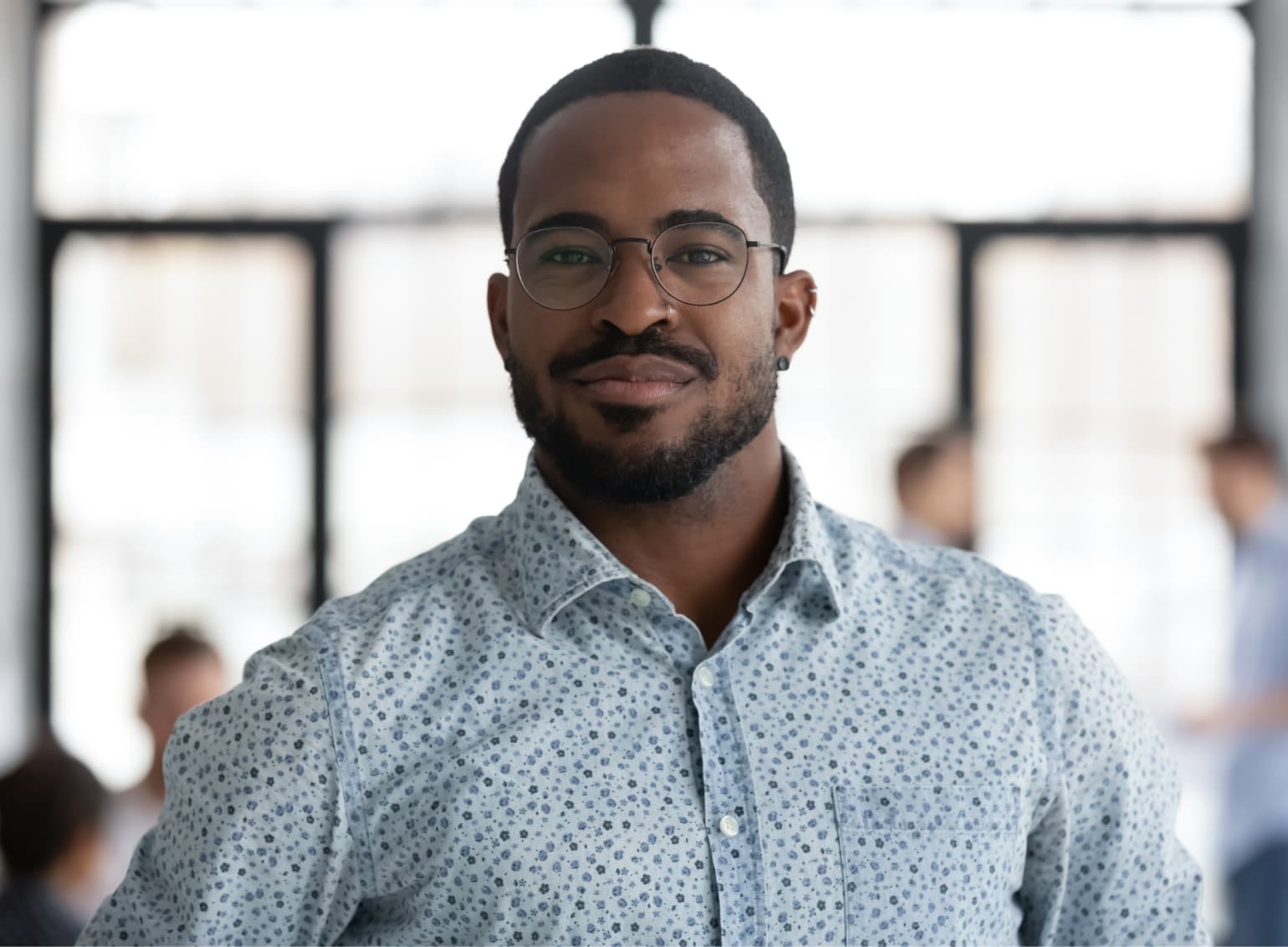 Portrait of businessman in glasses wearing a blue collared shirt